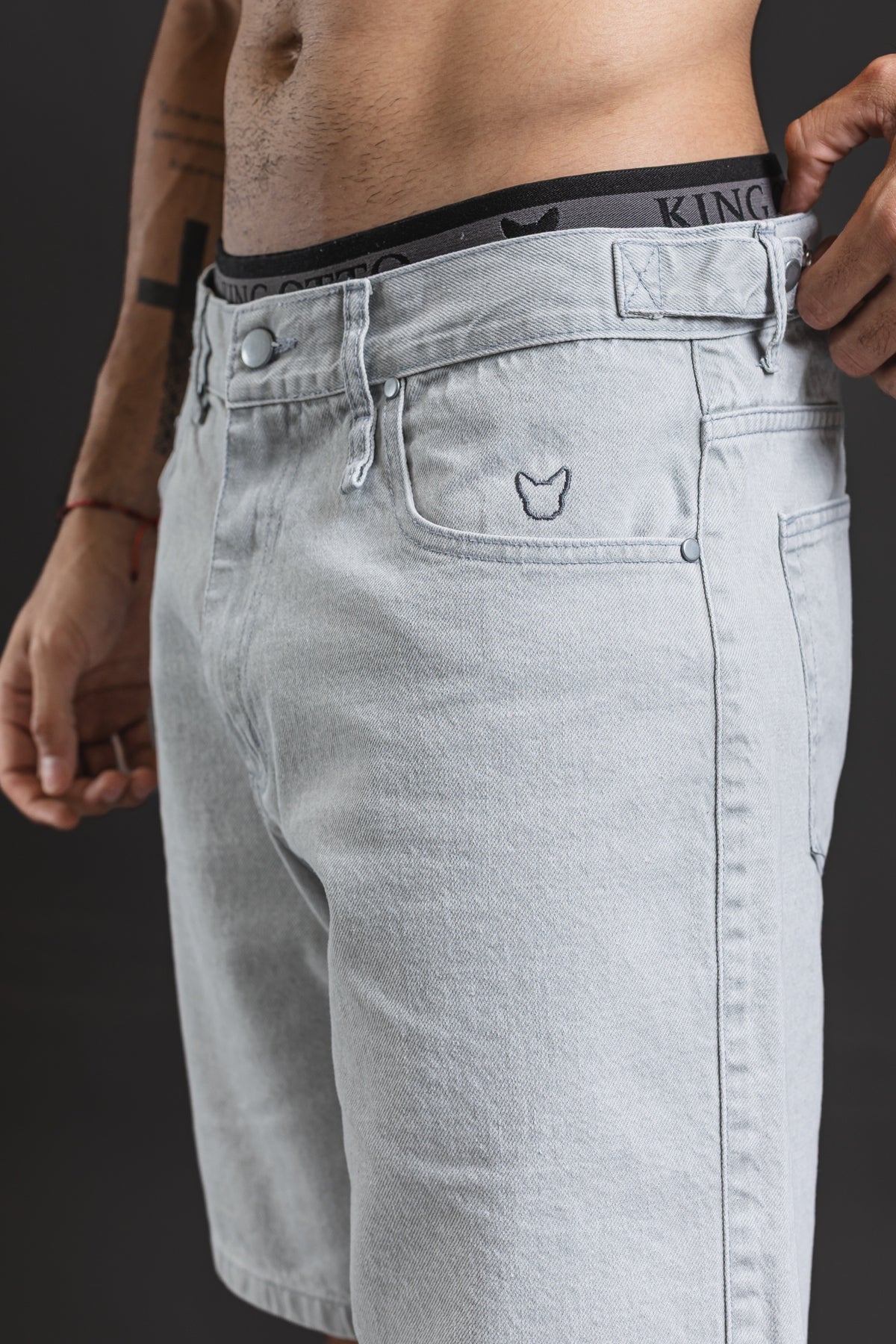 Bermuda OTTO Gris Perla, detalle del bulldog bordado y el ajuste lateral de la cintura