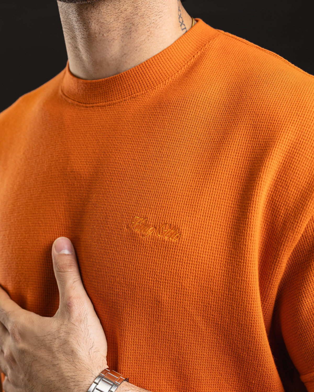 Detalle del tejido waffle y logo King Otto bordado tono sobre tono en la Boxy Block Orange