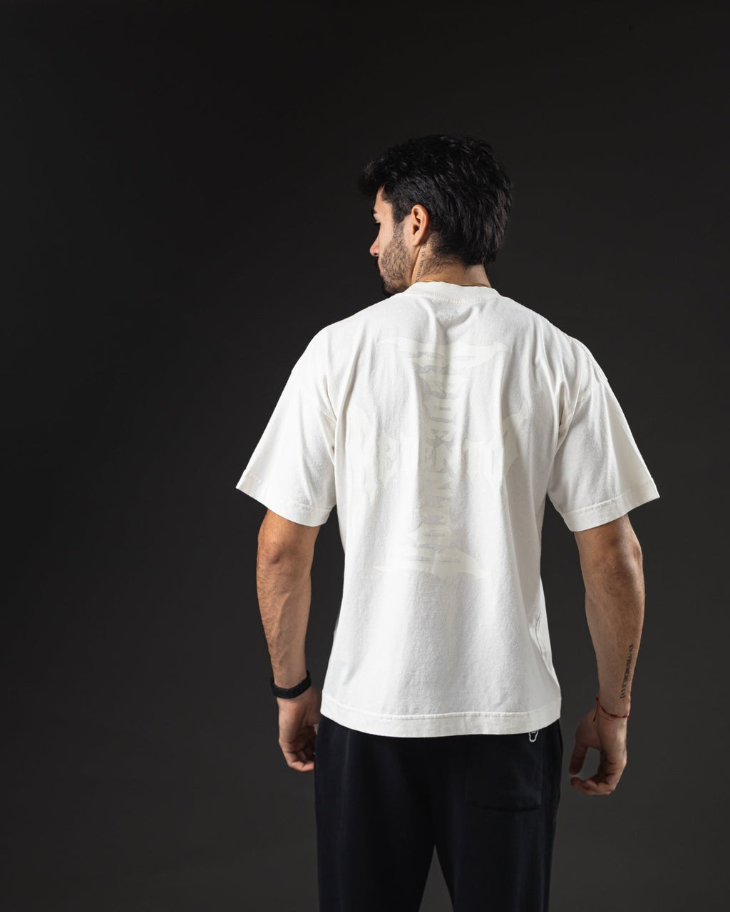 Remera oversize REDENTOR Cross marfil de espalda, hombros caídos