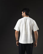 Remera oversize REDENTOR Cross marfil de espalda, hombros caídos