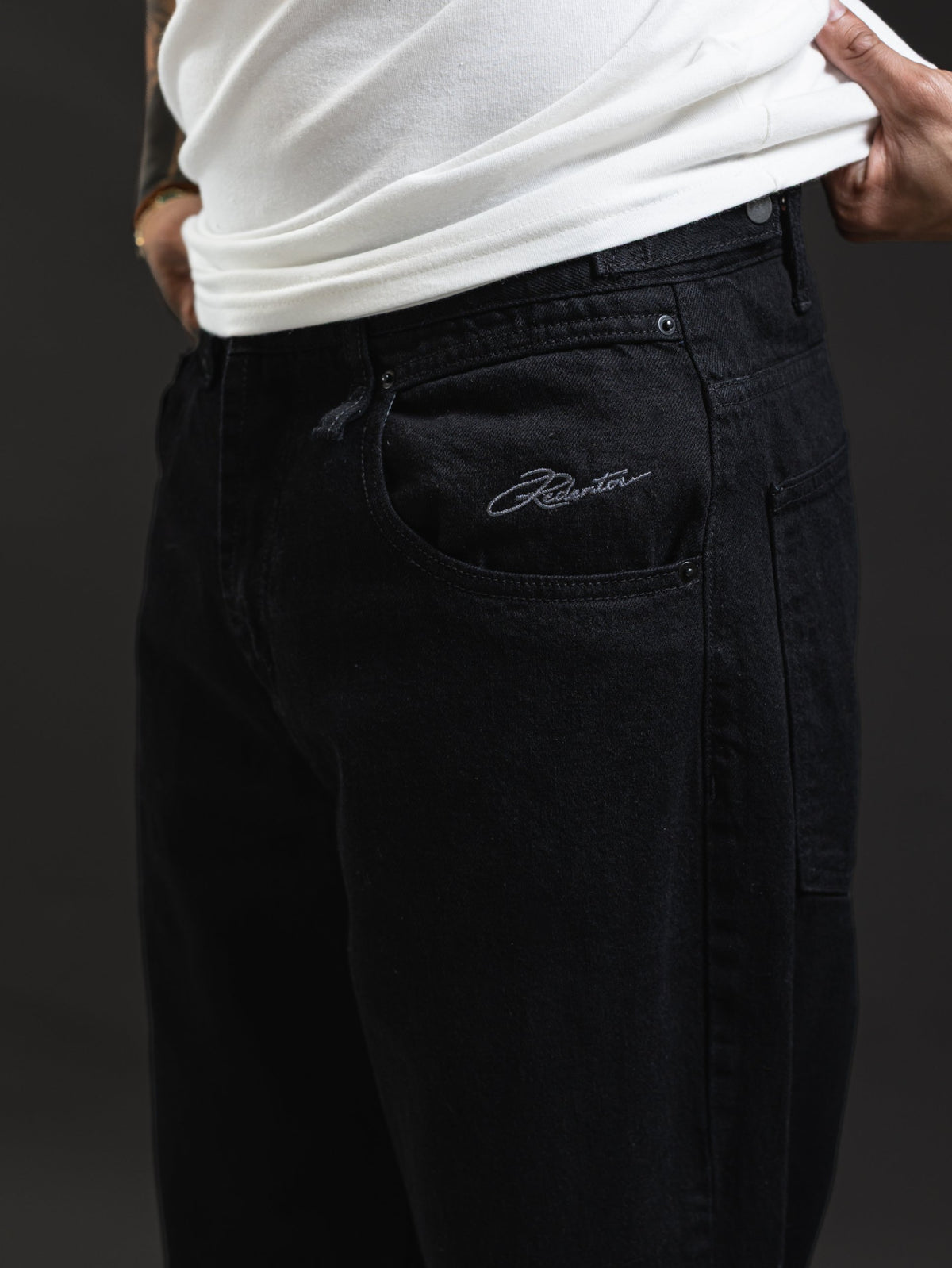 Jean REDENTOR Flare Negro Oscuro, detalle de la firma bordada en gris