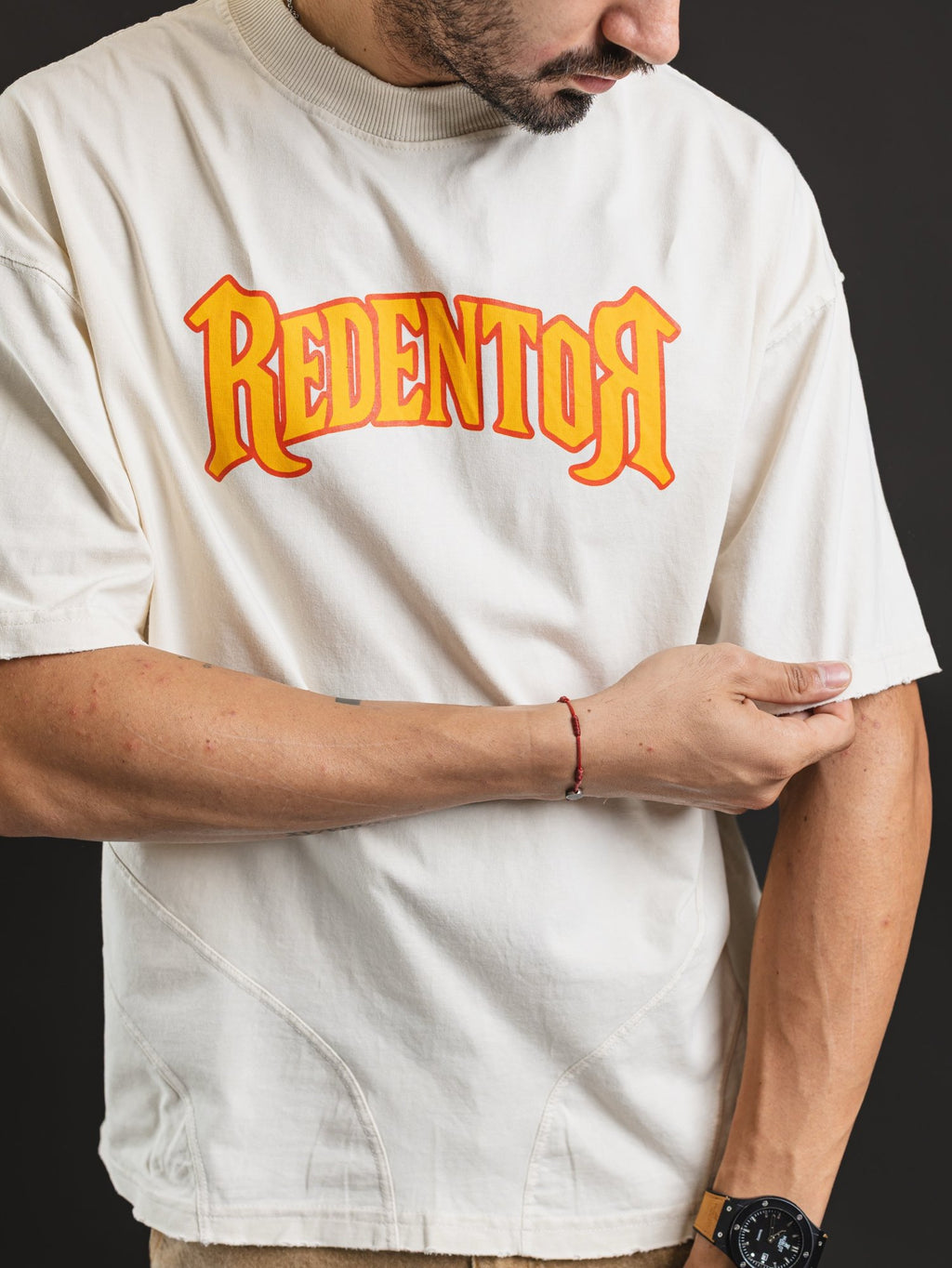 Remera oversize REDENTOR Multi Marfil - estampa REDENTOR naranja y cortes frontales
