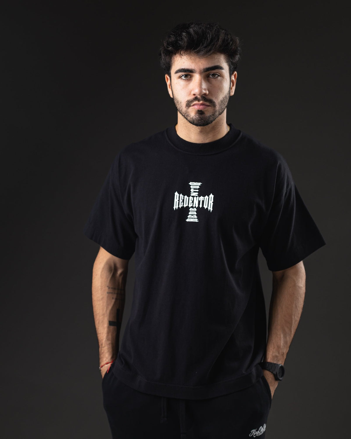 Remera oversize REDENTOR Sacred Fire negra de frente con logo Redentor en cruz blanco